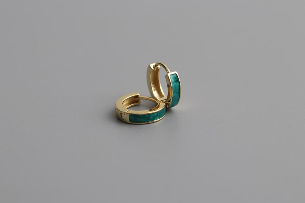 a pair of gold and turquoise rings