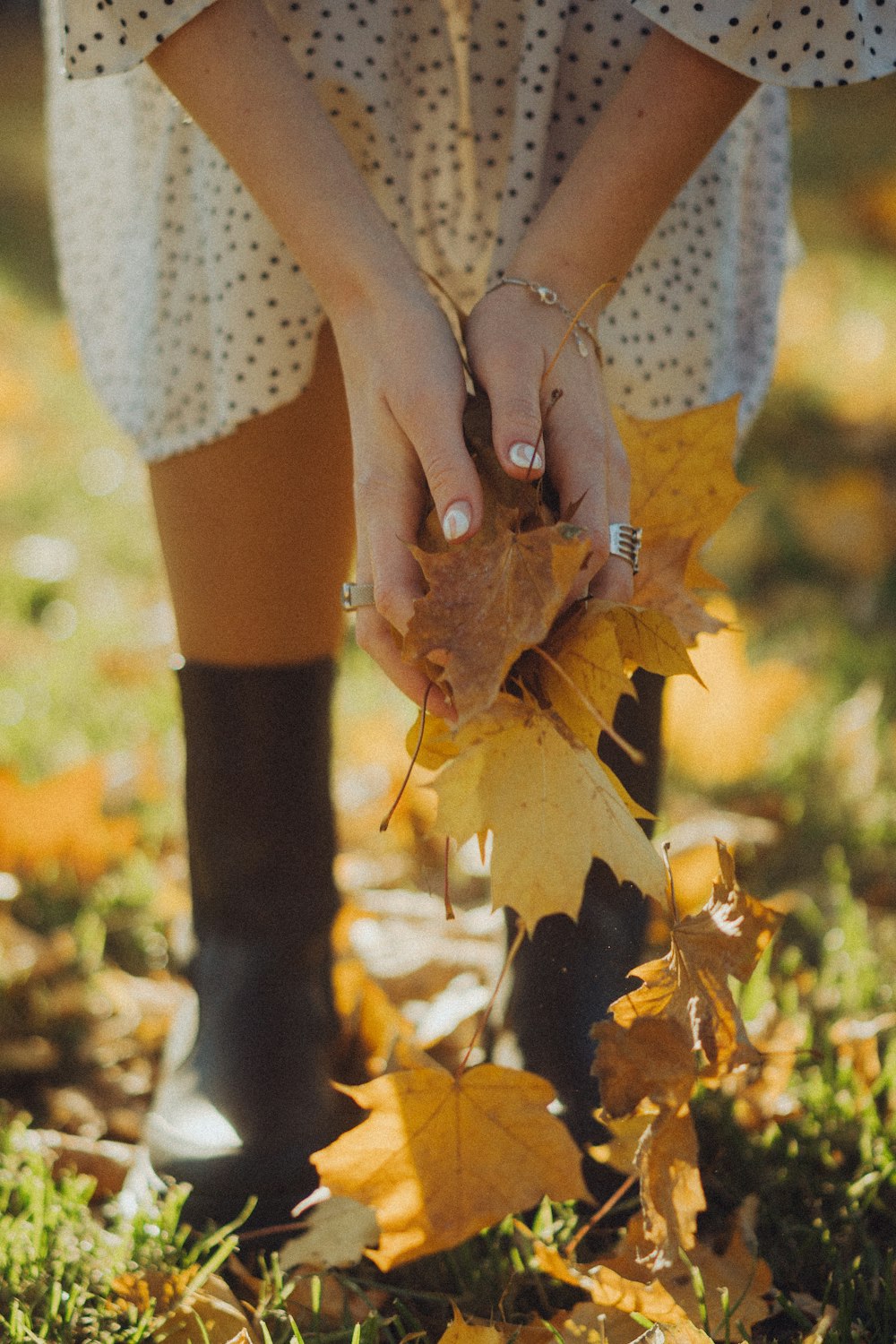 a woman in a polka dot dress holding a leaf