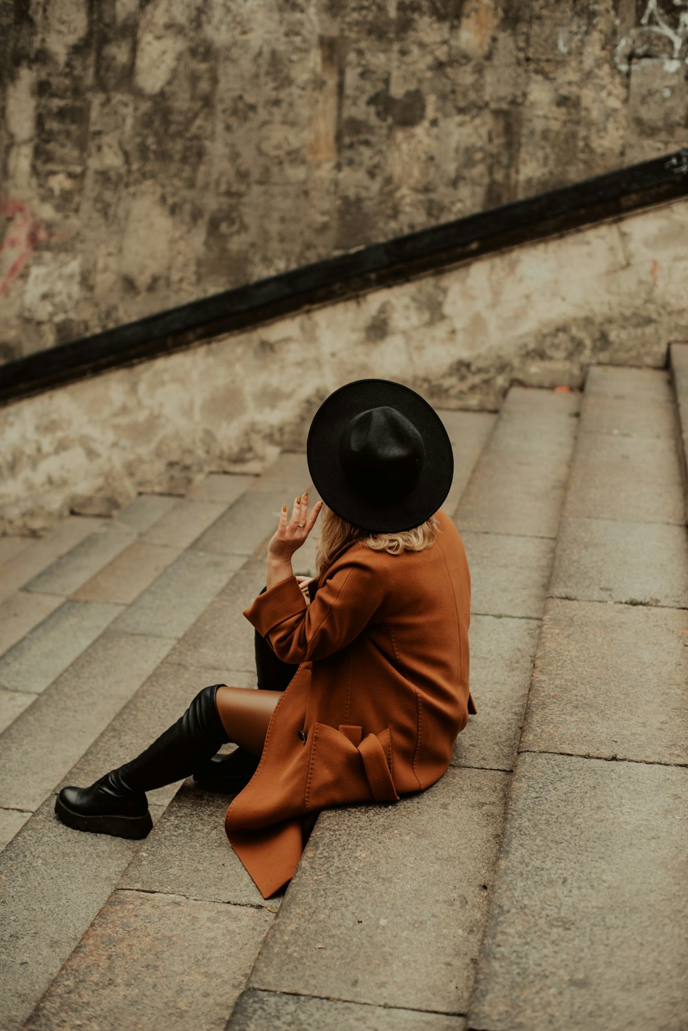 a boy sitting on a sidewalk