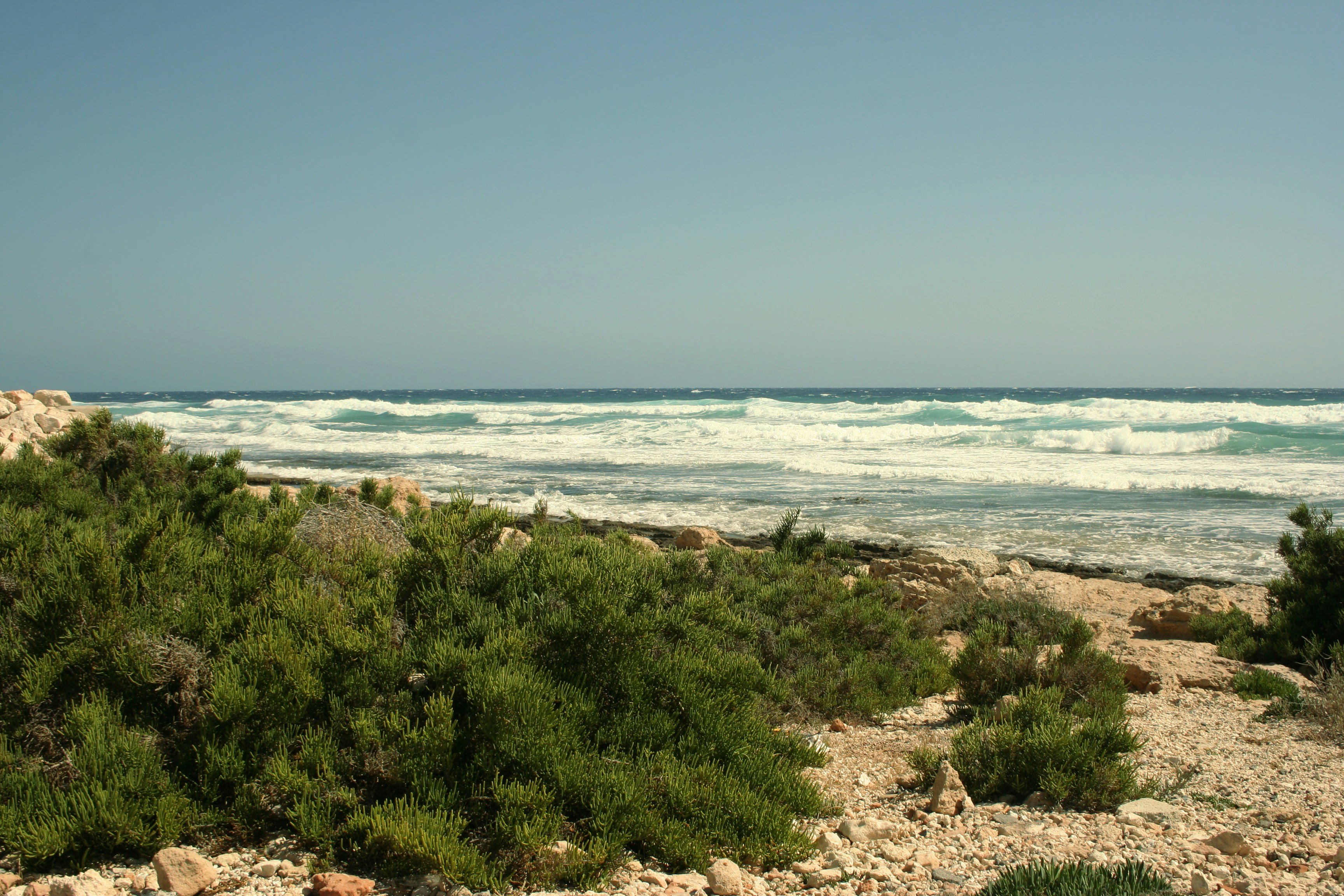 a view of the ocean from a rocky beach