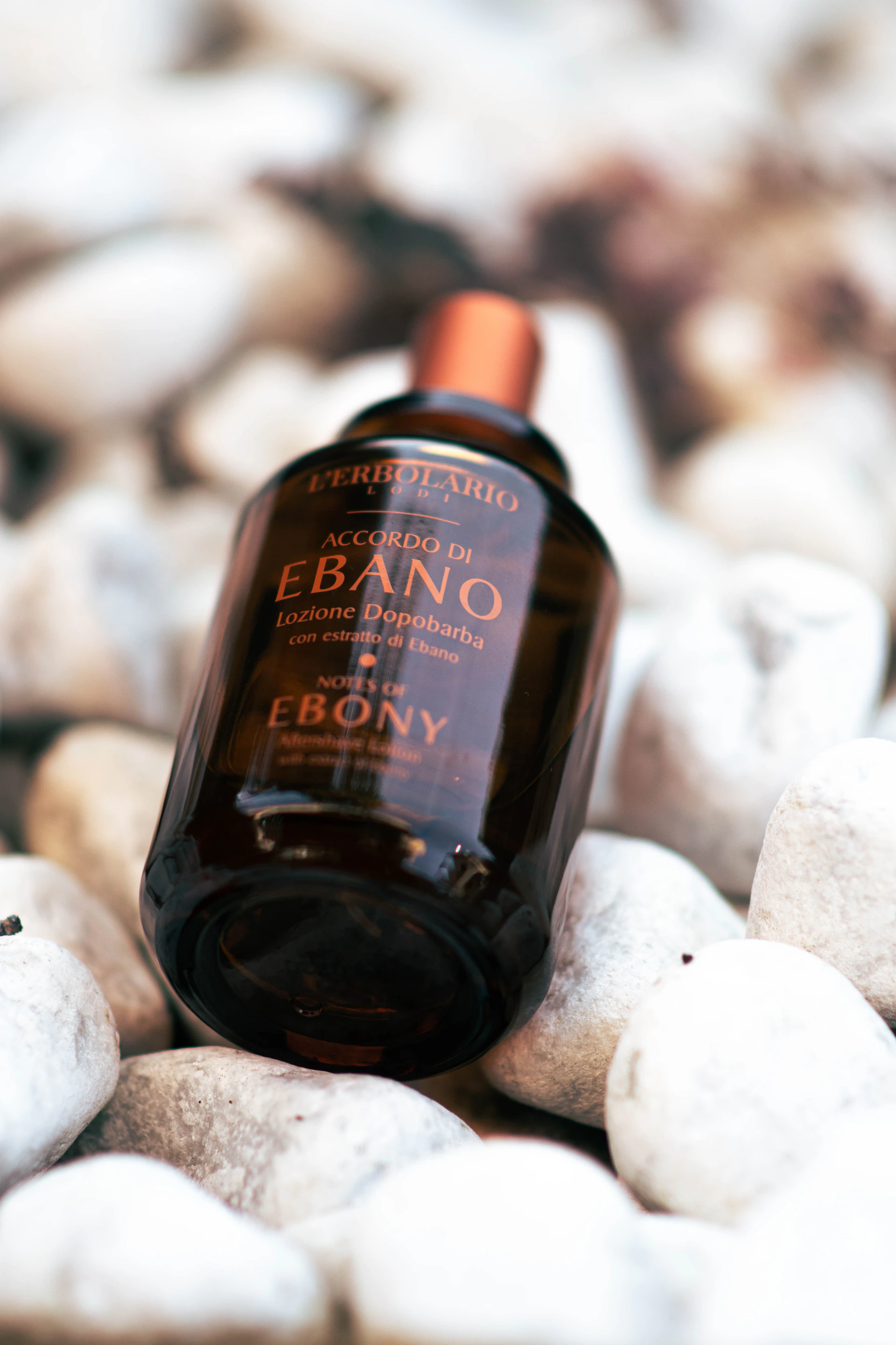 a brown bottle sitting on top of a pile of white rocks