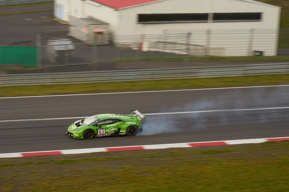 a green car driving down a race track