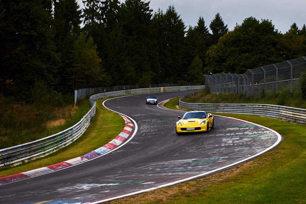 a yellow sports car driving down a race track