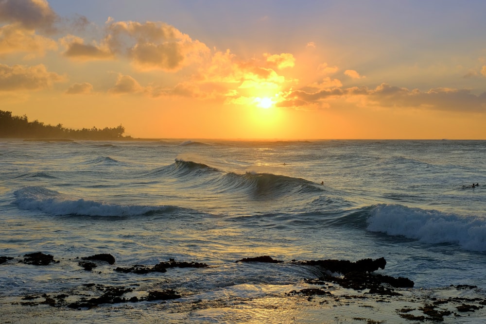 Il sole sta tramontando sull'oceano con le onde