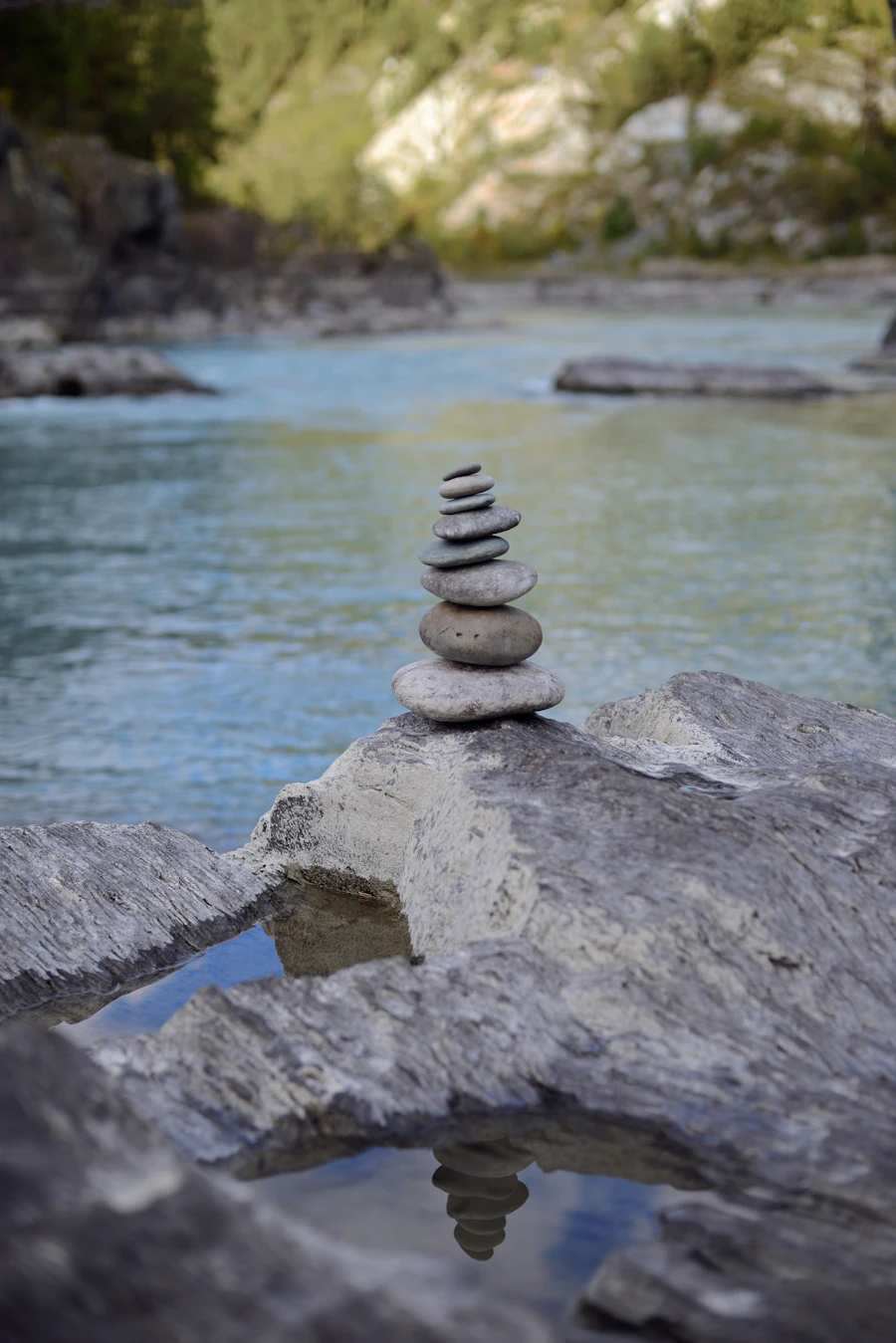 Smooth stones stacked in a gently flowing river