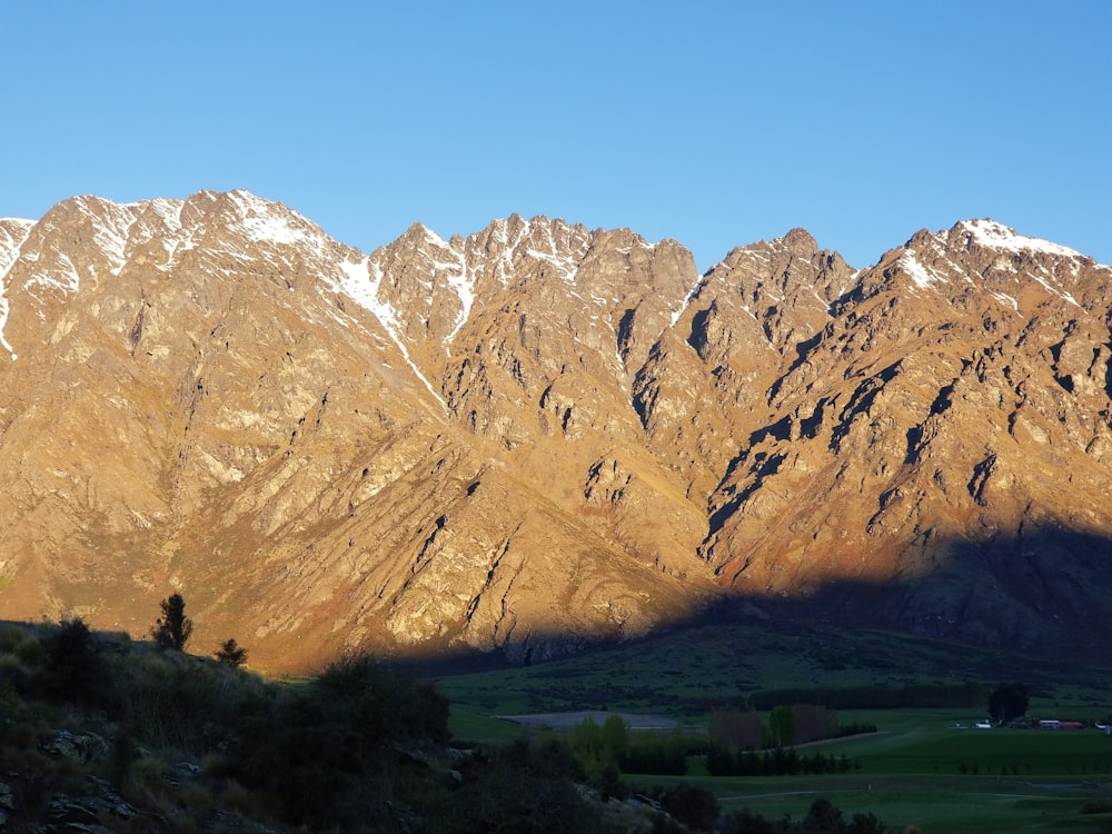 a view of a mountain range with the sun shining on it