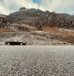 a black car parked on the side of a road
