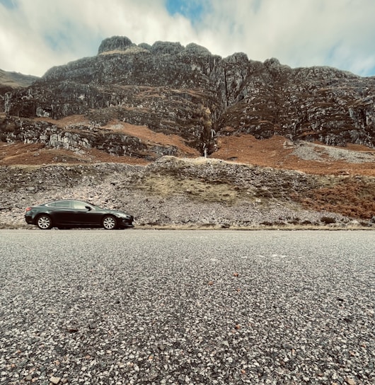 a black car parked on the side of a road