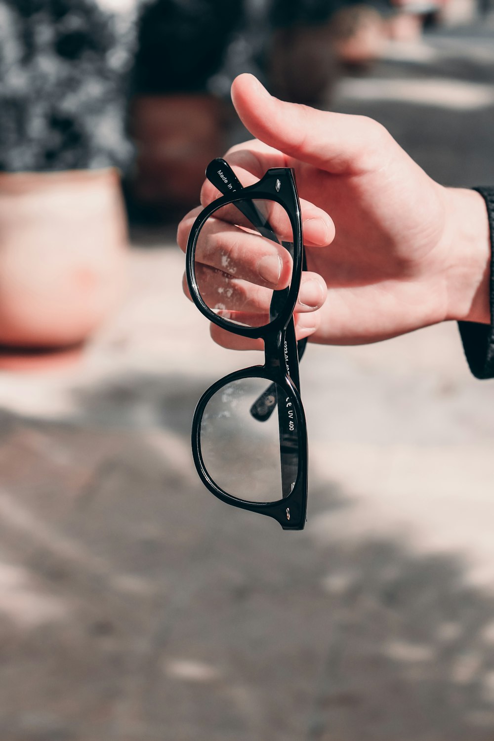 a hand holding a pair of black glasses