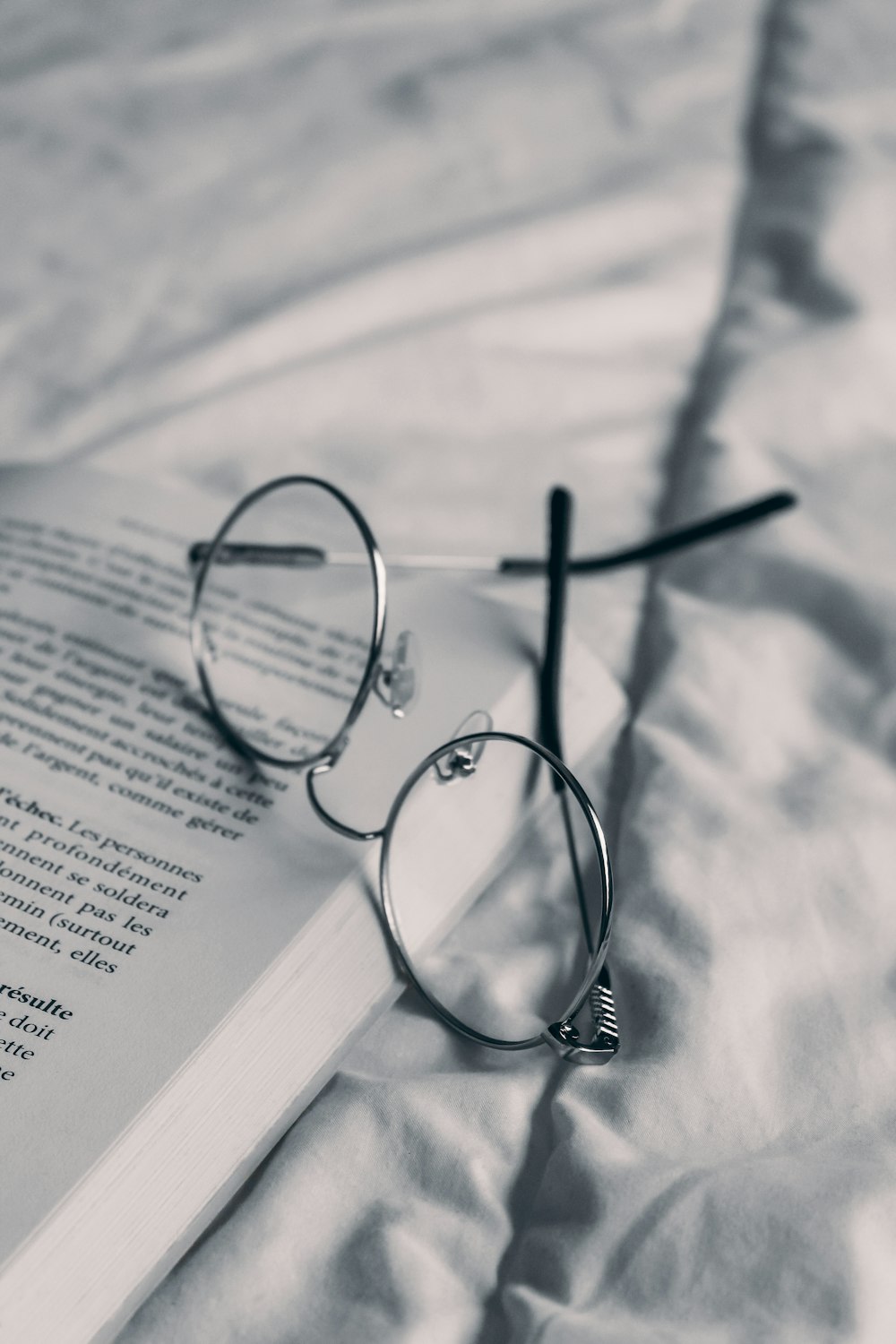 a pair of glasses resting on an open book