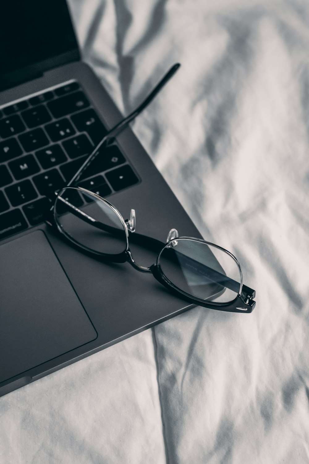 a pair of glasses sitting on top of a laptop computer