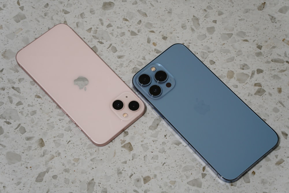 Deux iPhones côte à côte sur une surface en marbre