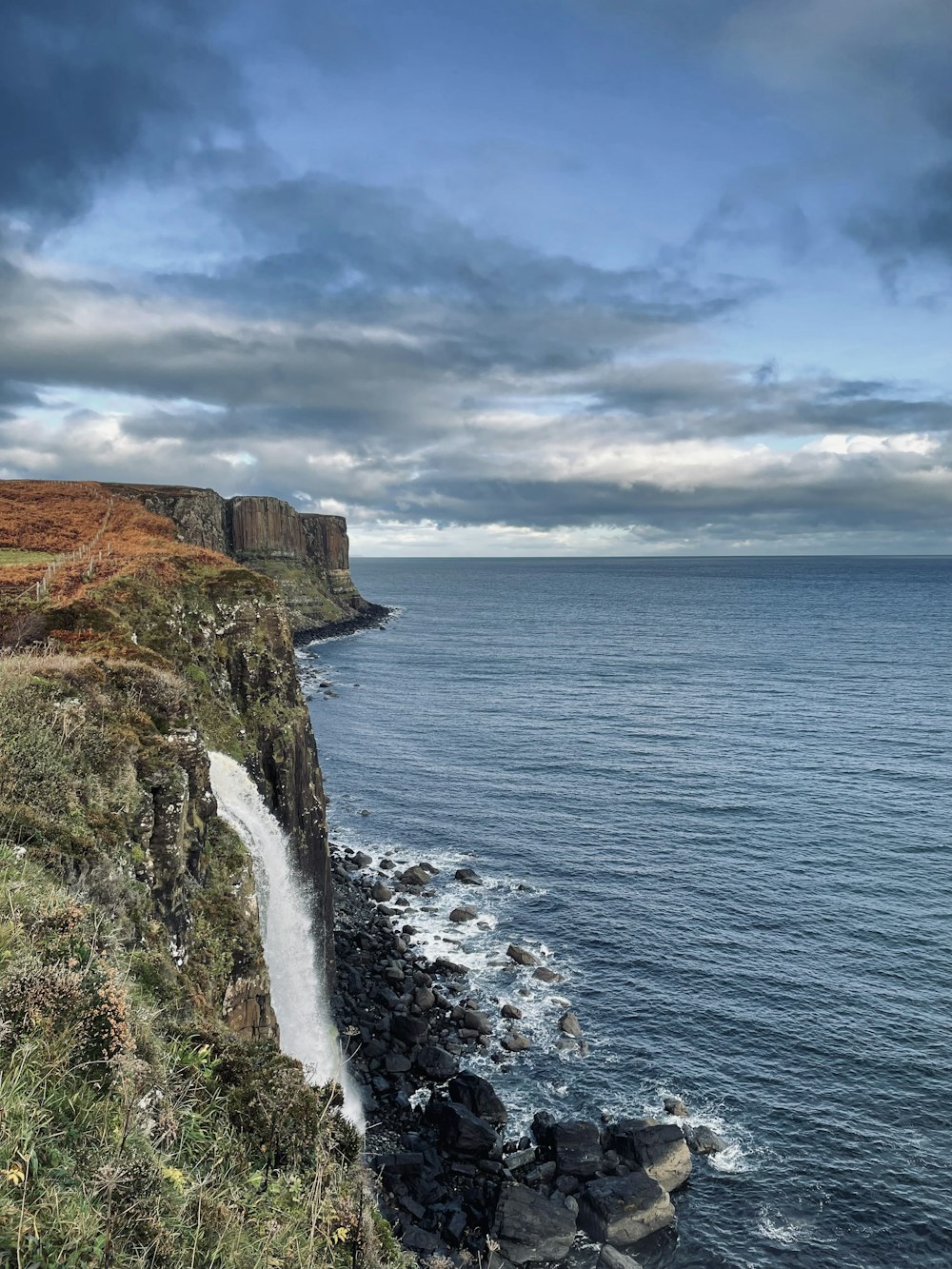 un grand plan d’eau à côté d’une falaise