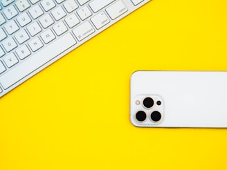 a white iphone sitting on top of a yellow table