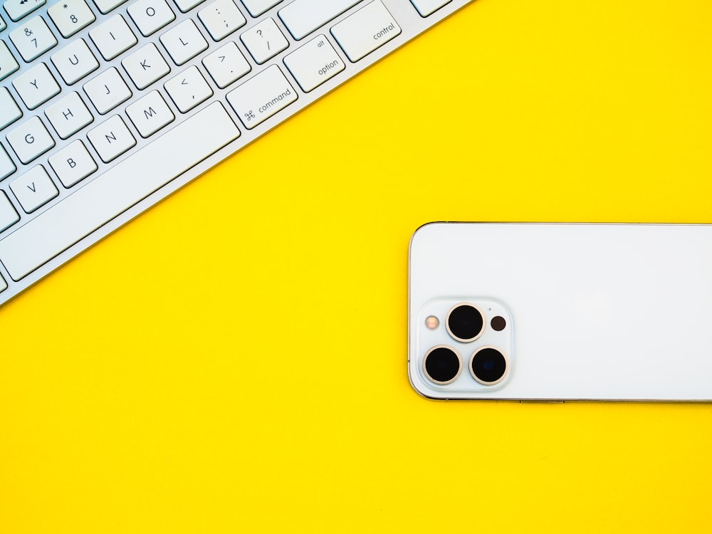 a white iphone sitting on top of a yellow table