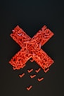 a cross made out of small pieces of red plastic