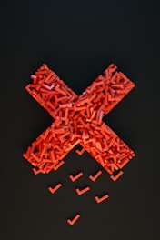 a cross made out of small pieces of red plastic