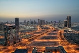 Aerial view of a modern city skyline with sleek glass buildings at dusk.