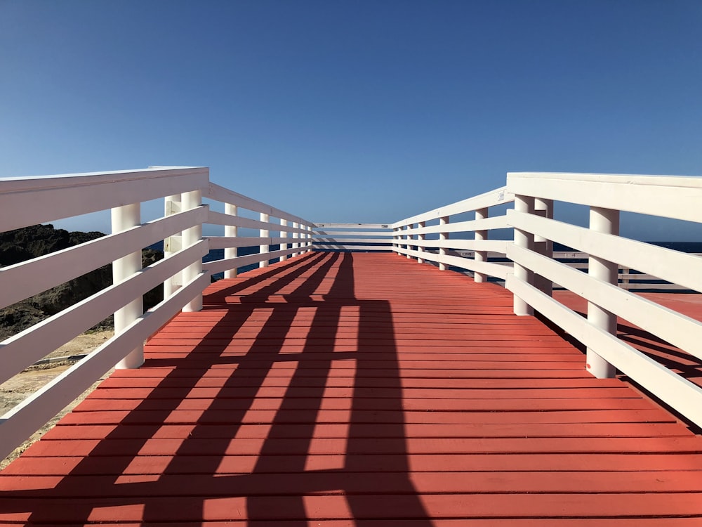 a red and white bridge with a blue sky in the background