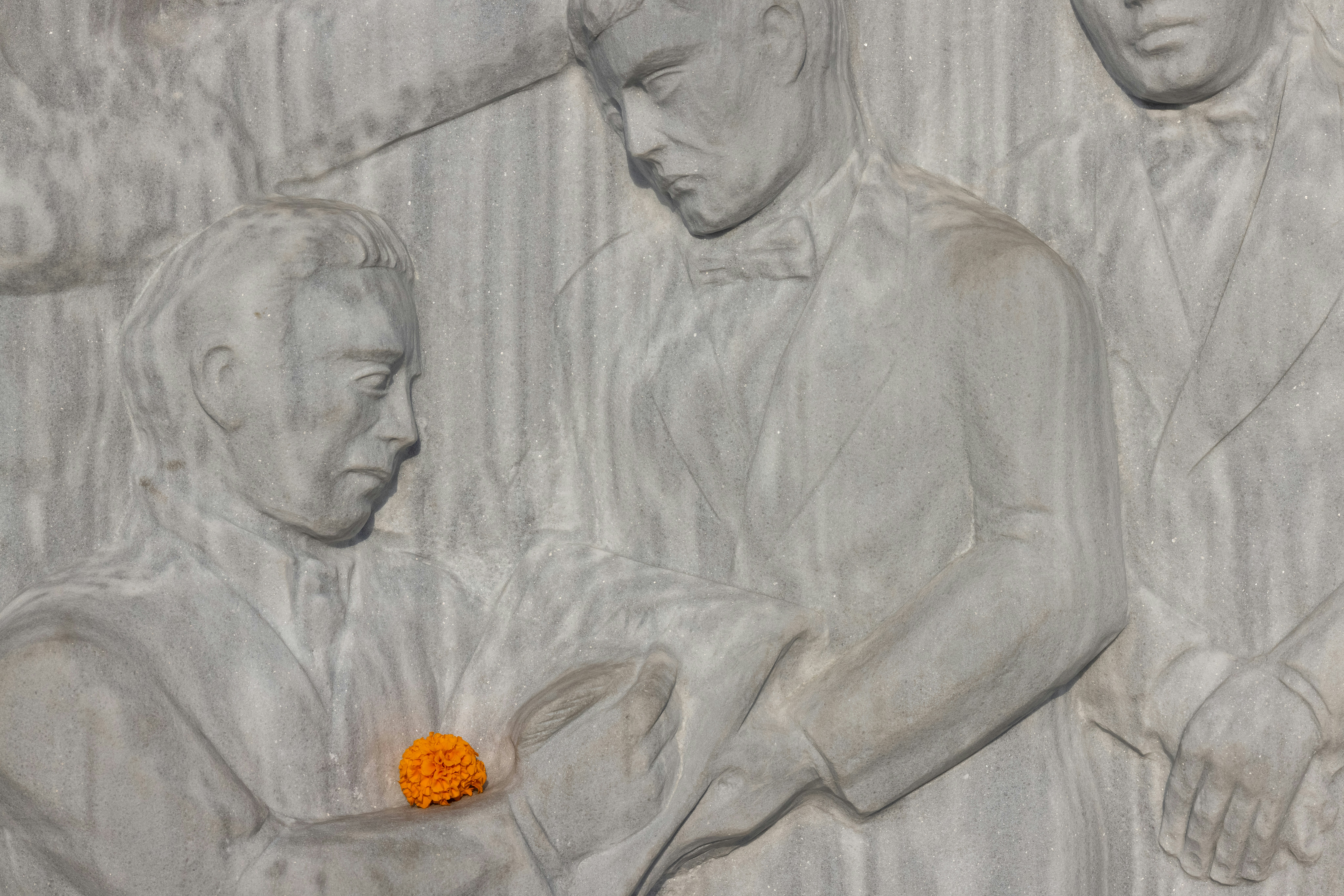 a close up of a carving of a man with an orange ball in his hand