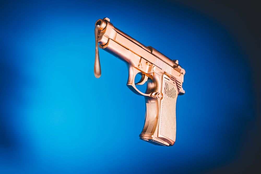 a gold gun with a drop of liquid hanging from it