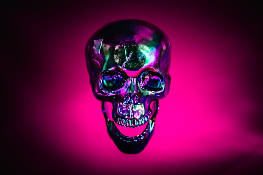a purple and black skull on a pink background
