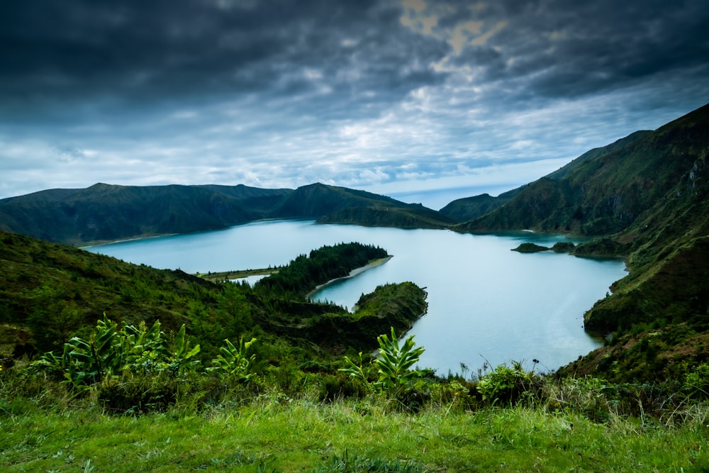 a large body of water surrounded by lush green hills