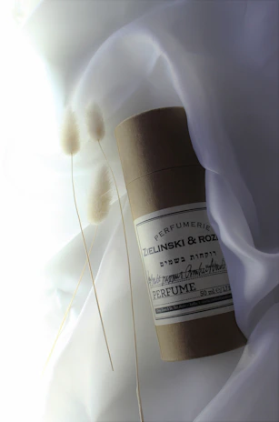 An elegant flat lay of Jordy Esencia perfumes with fresh flowers and minimalist decor.