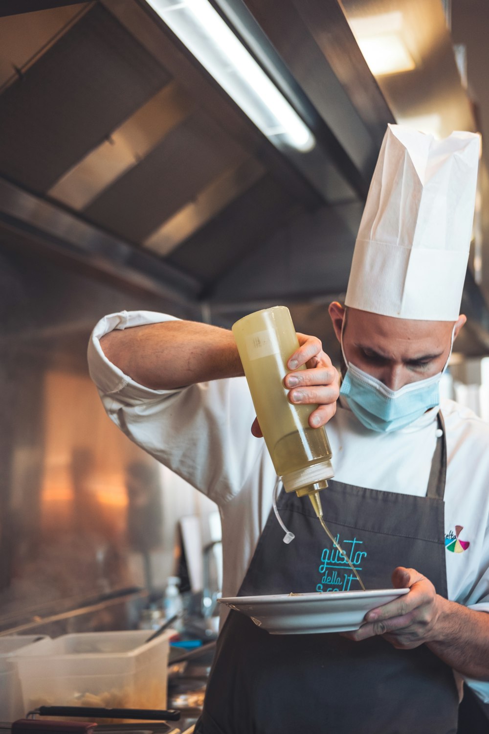 a man in a chef's hat is pouring something into a bowl
