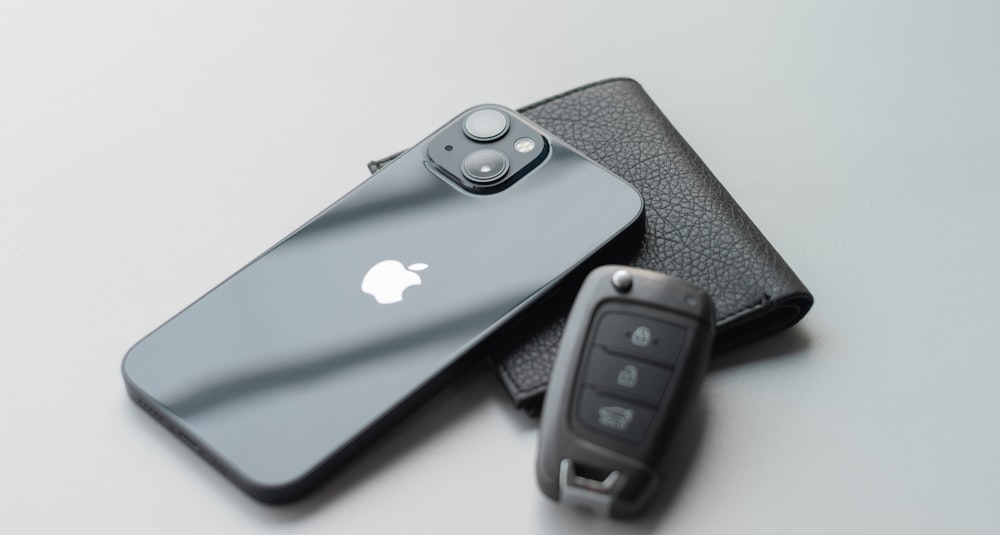 a cell phone sitting next to a car key
