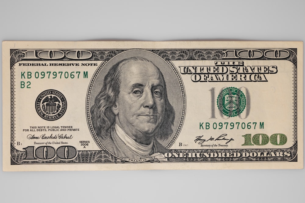 un billete de cien dólares con una imagen de la cara de un hombre