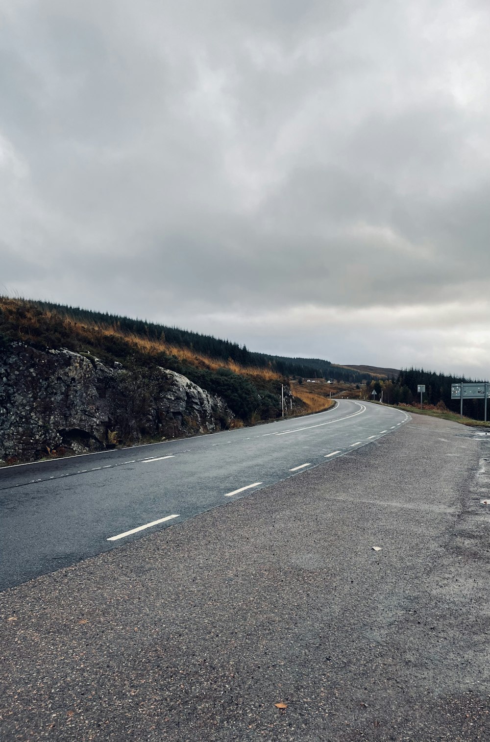 an empty road with a hill in the background