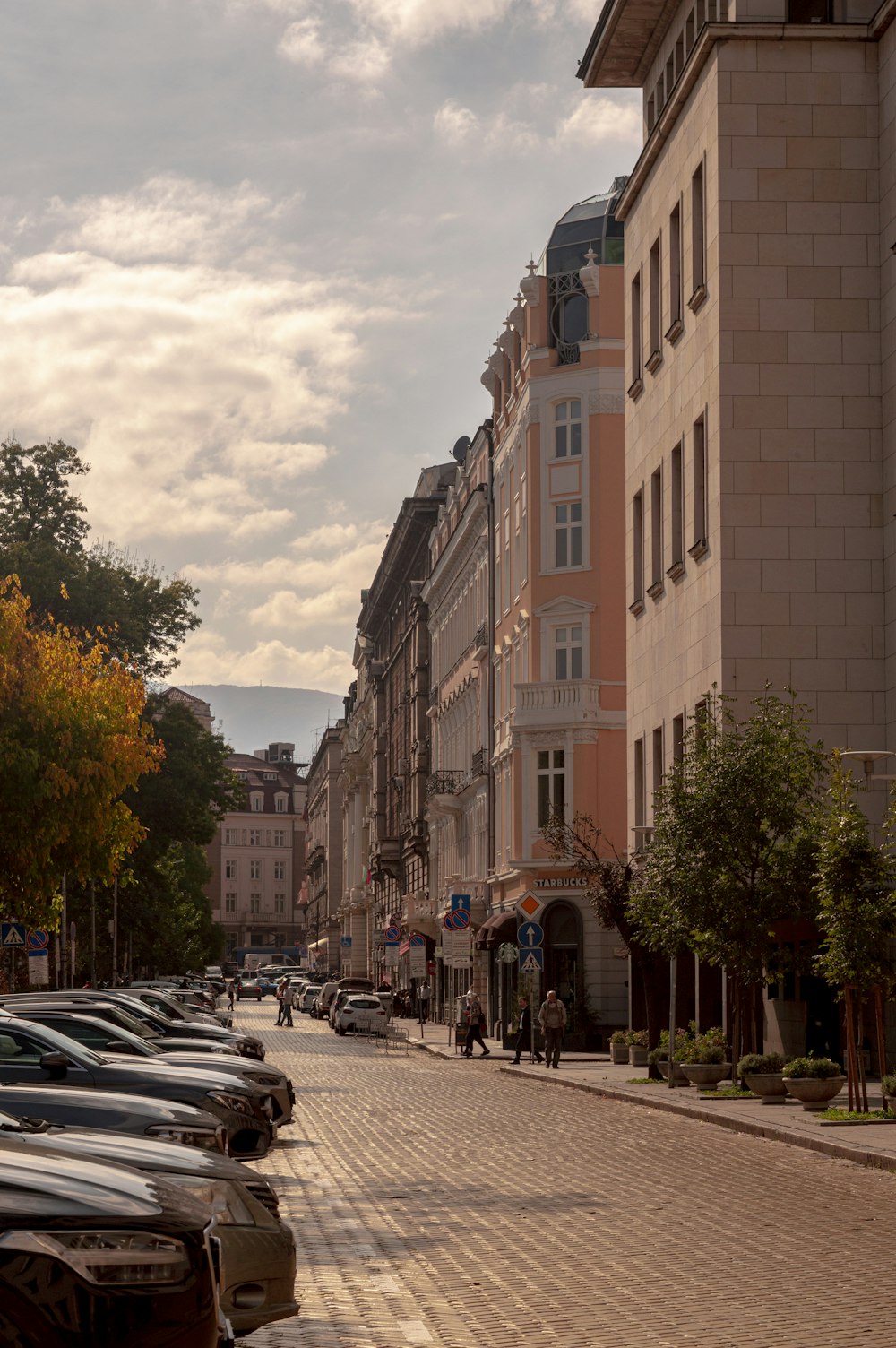 a row of parked cars sitting on the side of a road