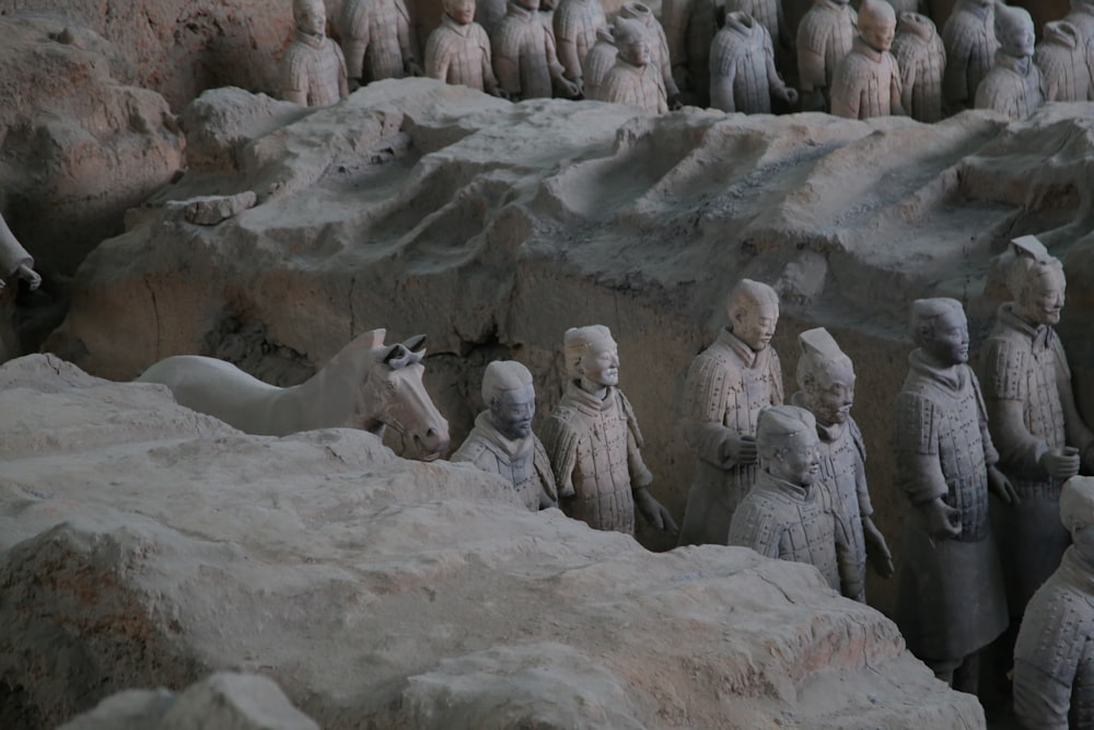 Un grupo de estatuas de personas de pie una al lado de la otra