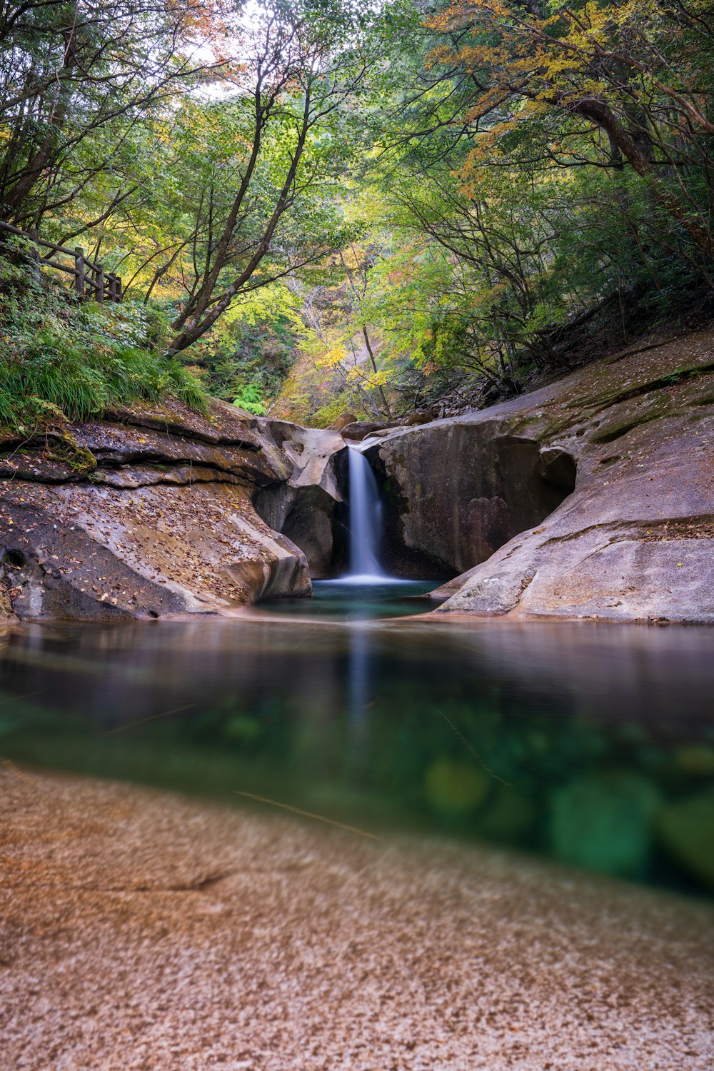 a small waterfall in the middle of a forest