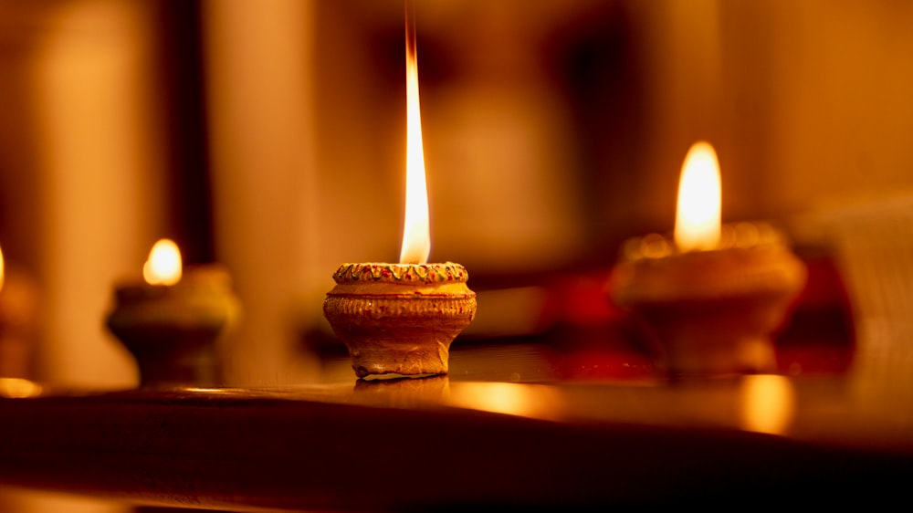 a lit candle sitting on top of a wooden table