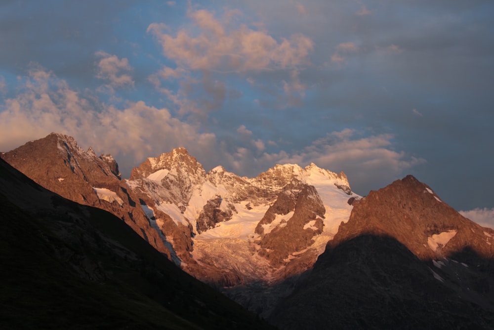 a snow covered mountain with clouds in the sky