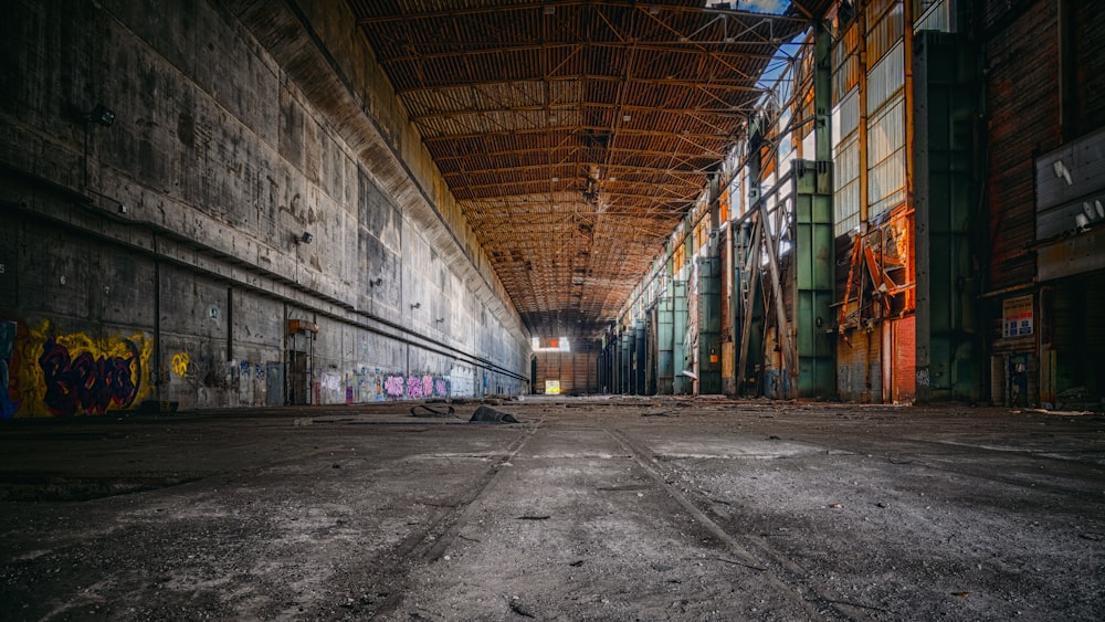 an empty warehouse with graffiti on the walls