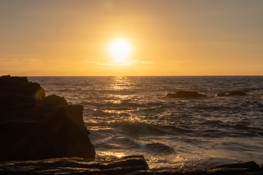 the sun is setting over the ocean with waves