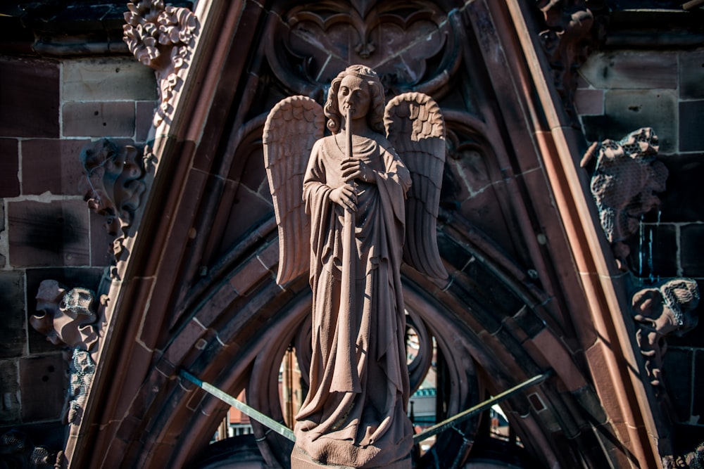 a statue of an angel on the side of a building