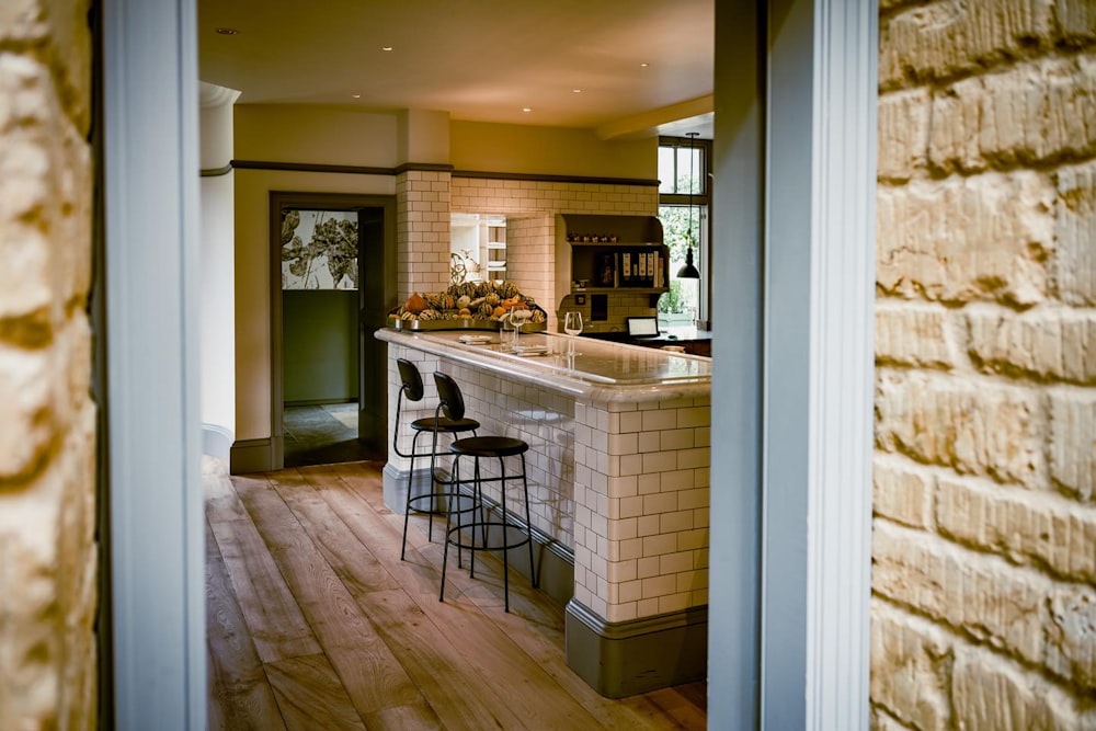 a kitchen with a bar and two stools