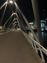Night shot of a lit-up pedestrian bridge with clean lines and modern materials.