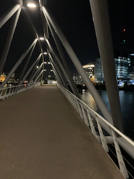 Night shot of a lit-up pedestrian bridge with clean lines and modern materials.
