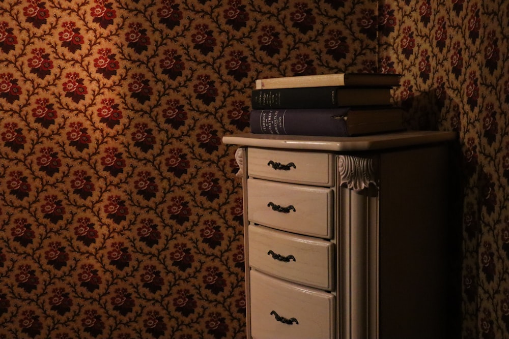 a dresser with a stack of books on top of it