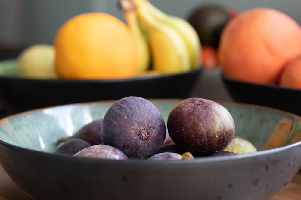 a bowl of fruit sitting on top of a wooden table
