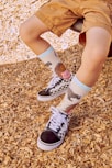 a young boy wearing a pair of black and white shoes