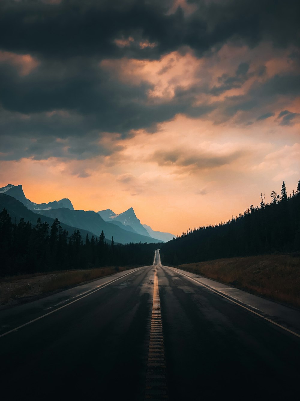 Una lunga strada con le montagne sullo sfondo