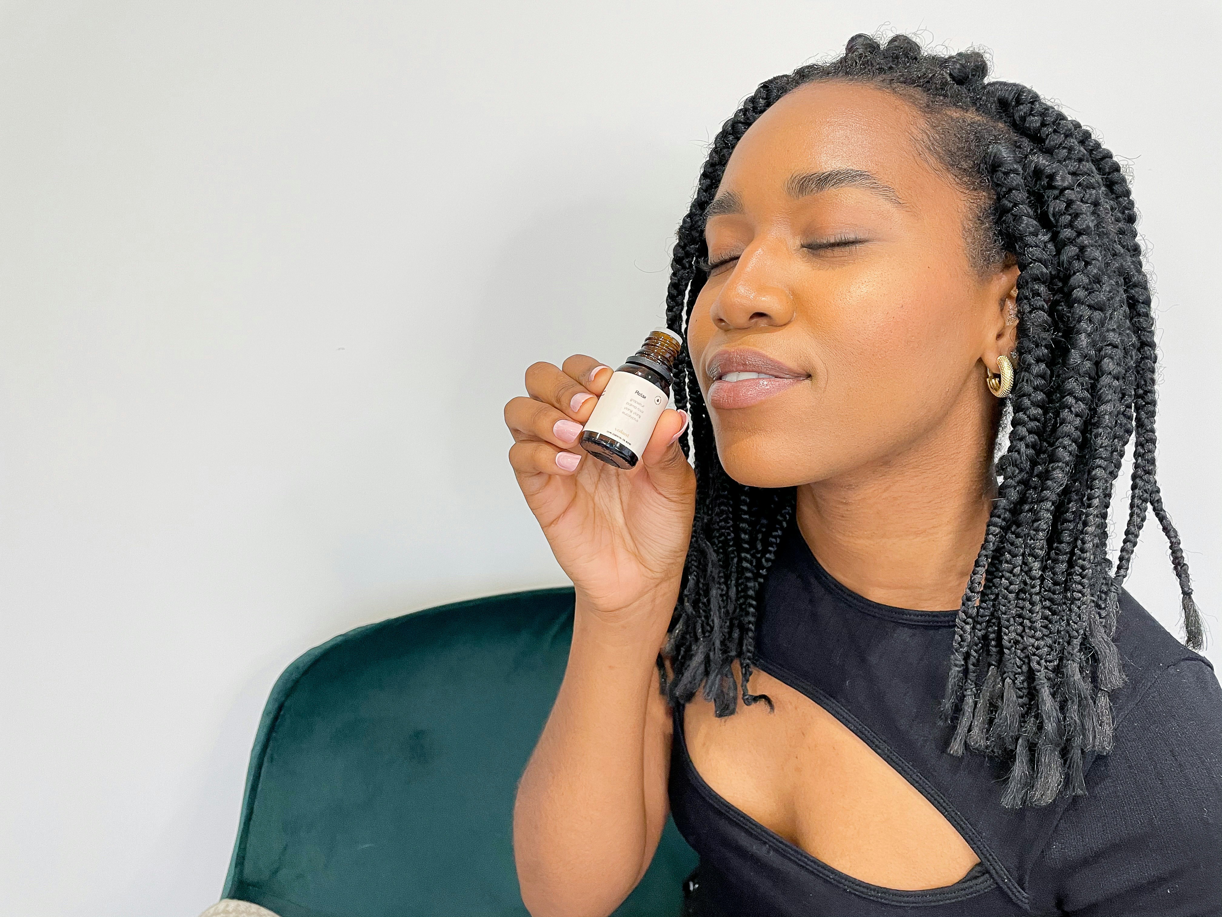 a woman sitting on a green chair with a bottle in her hand