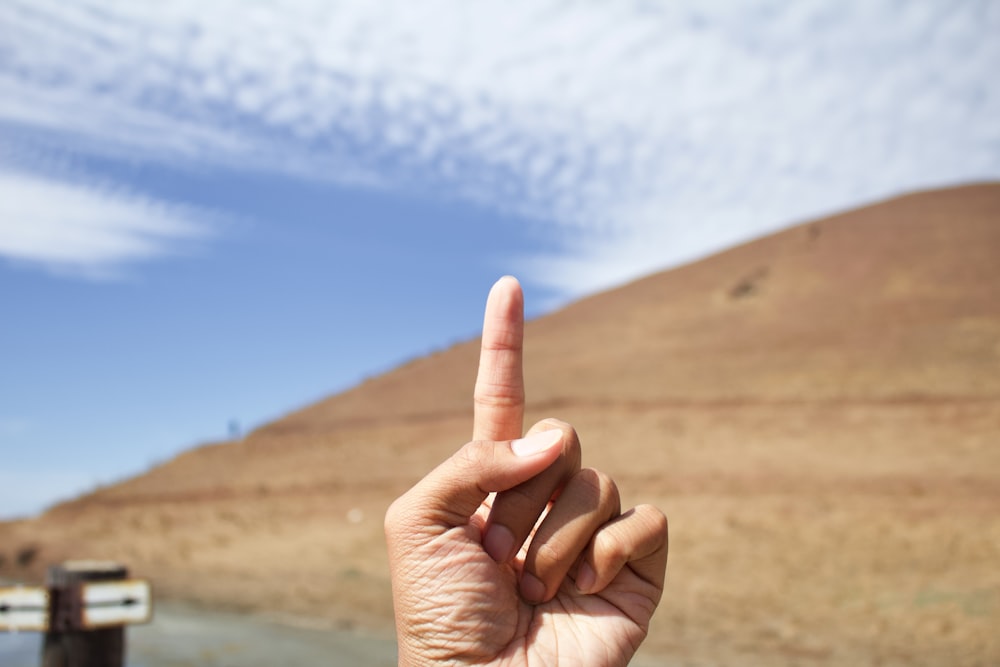 a person making a peace sign with their fingers