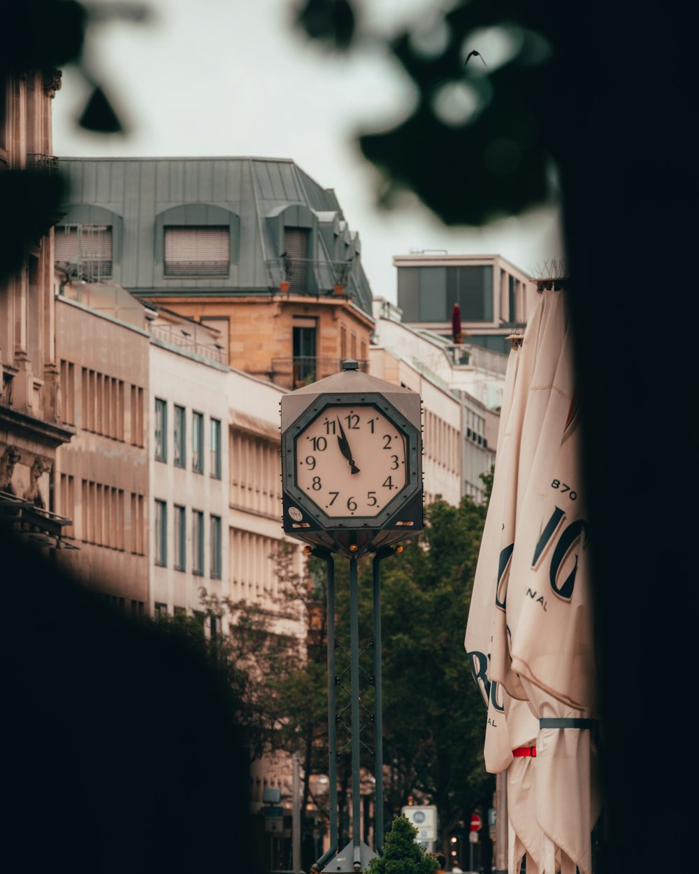 a clock on a pole in the middle of a city